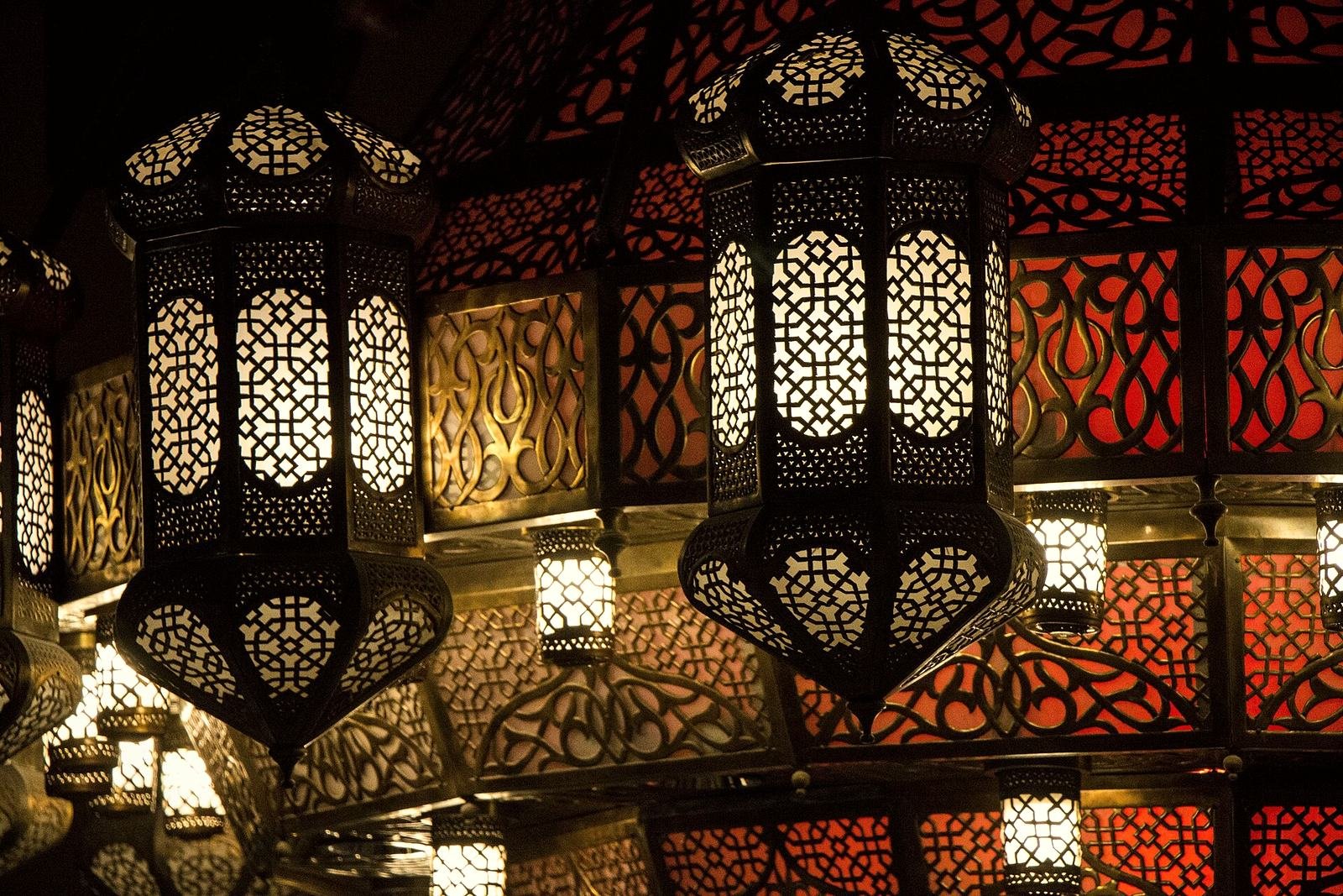 Pierced brass Arabic lanterns glowing gold and red